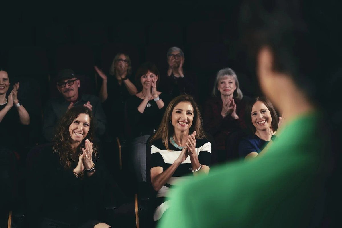 Audience members reacting and laughing during an Icon Experience stage session.