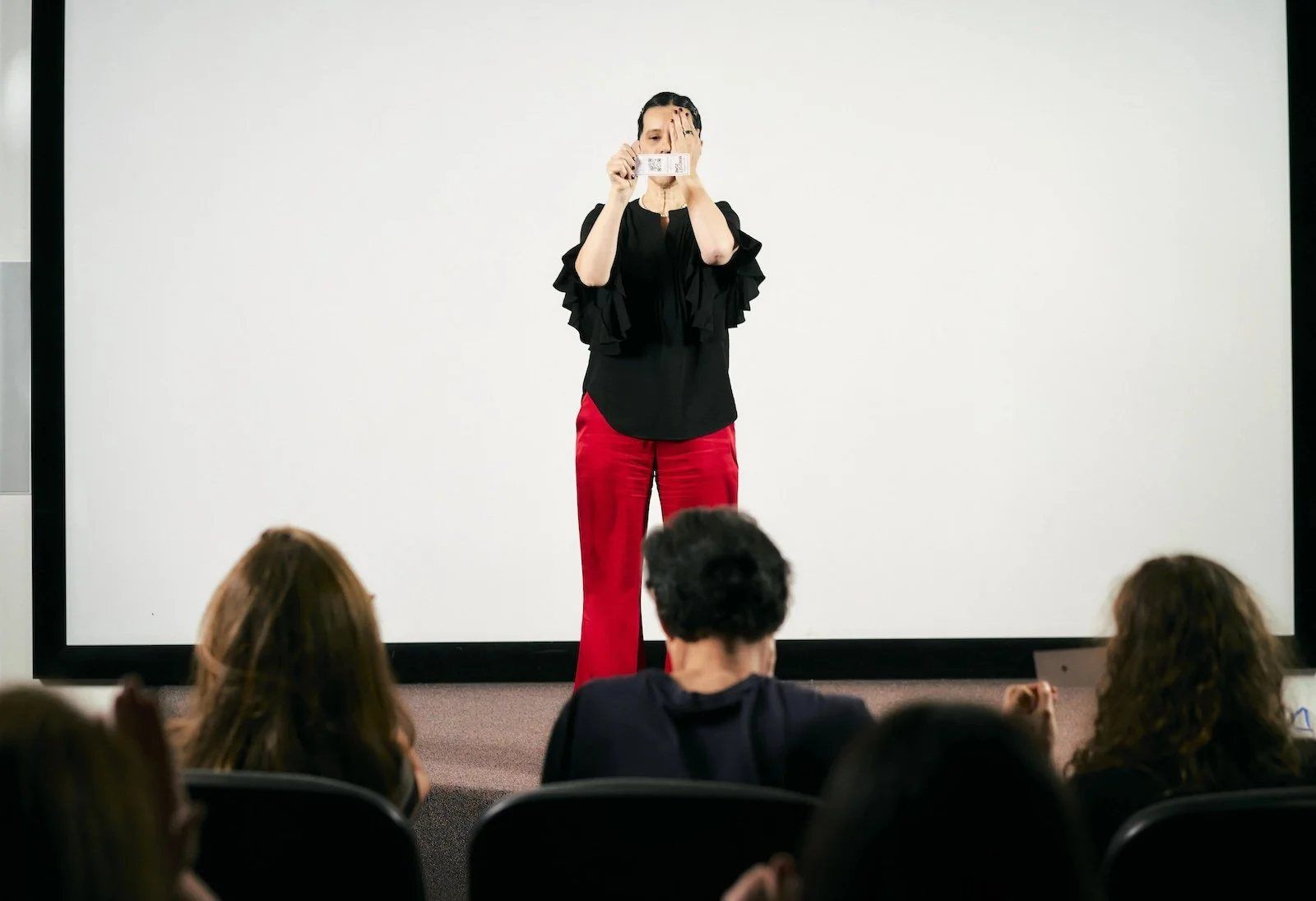 A speaker mid-gesture on stage during a Series A Photography Icon Experience session, lit for a speaker media kit.